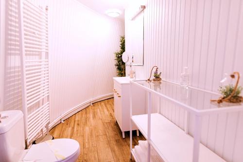 a white bathroom with a toilet and a sink at Wegloo in Azuga