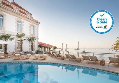 a swimming pool at a hotel with a sign that says clean and safe at The Albatroz Hotel in Cascais