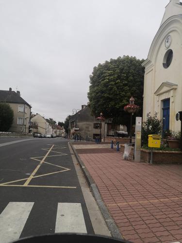 an empty street in a town with a church at Cosy village in Bonneuil-en-France