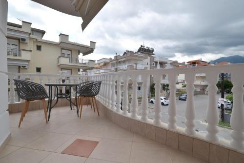 a balcony with a table and chairs and some buildings at Epavlis Luxury apts in Leptokaria