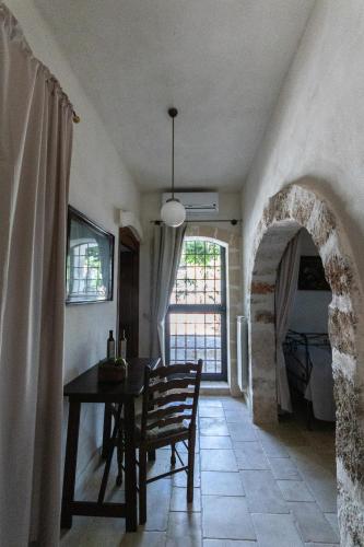 a dining room with a table and a stone archway at Masseria Parco di Castro in Montalbano