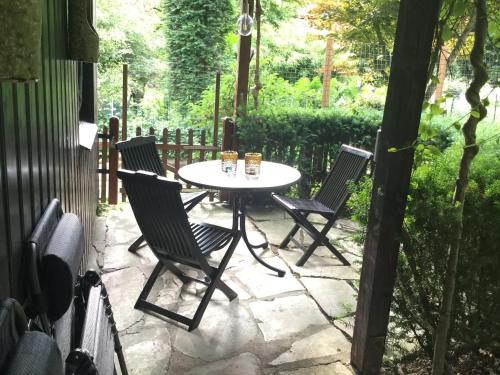 a table and chairs on a stone patio at Wohnidylle auf schönem Anwesen im Wald in Bad Honnef am Rhein