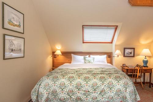 a bedroom with a bed and a table with a desk at Hastings House Country House Hotel in Ganges