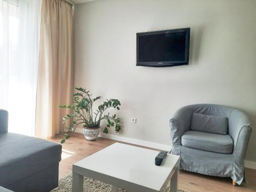 sala de estar con silla y TV en la pared en Rima's apartment en Palanga