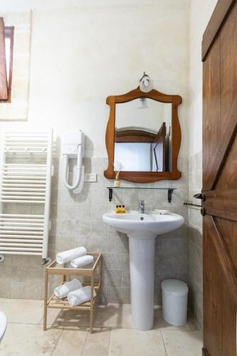 a bathroom with a sink and a mirror at Masseria Parco di Castro in Montalbano