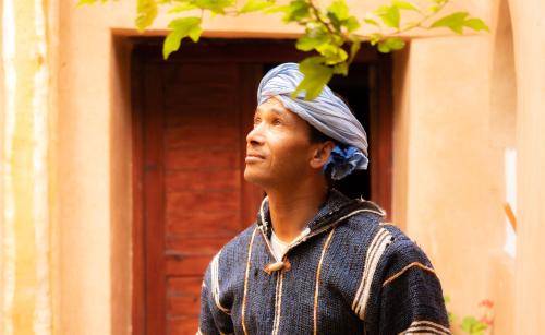 a man with a turban on his head standing in front of a building at Dar Essalama Dades in Akhendachou nʼAït Ouffi
