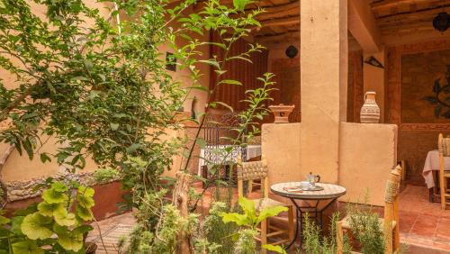 a patio with a small table and some plants at Dar Essalama Dades in Akhendachou nʼAït Ouffi