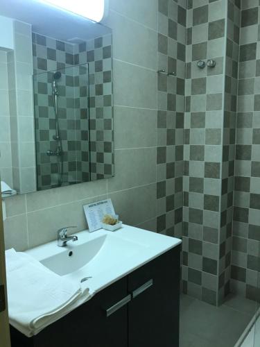 a bathroom with a sink and a shower with a mirror at Hotel Esteba in Caldes de Malavella