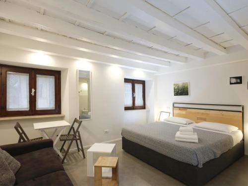 a white bedroom with a bed and a couch at Piano Tre in Verona