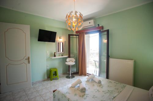 um quarto com uma cama e um lustre em Colourful apartments (Green Lagoon) em Argostoli