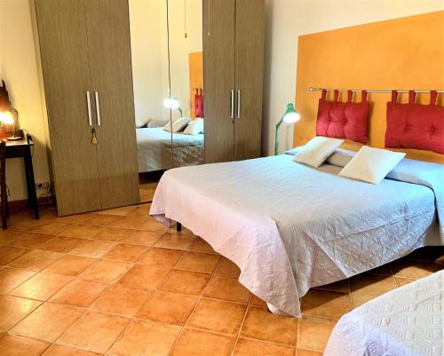 a bedroom with two beds with red pillows at Villetta Siciliana "Dal PICCIOTTO" in Marsala