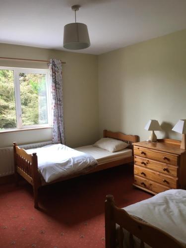 a bedroom with two beds and a window and a dresser at teach donal og in Falcarragh