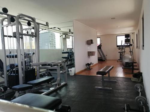 a gym with treadmills and chairs in a room at Hotel Campestre Inn in León