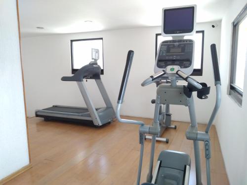 a fitness room with a treadmill and a mirror at Hotel Campestre Inn in León