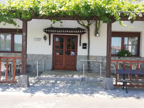 a building with a wooden door and a bench at Atxispe Etxea Casa Rural in Laukiz