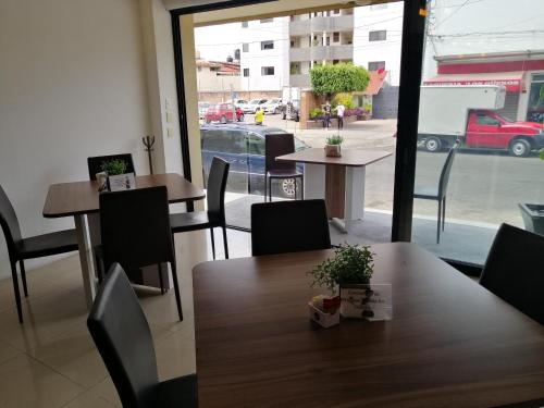 a restaurant with tables and chairs and a large window at Hotel Campestre Inn in León