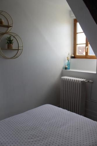une chambre blanche avec un lit et une fenêtre dans l'établissement Studio plein coeur d'Auxerre, à Auxerre
