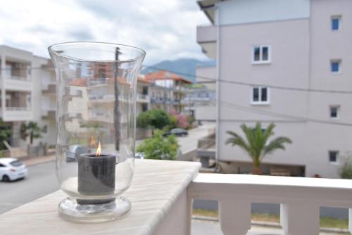 a candle in a glass vase on a balcony at Epavlis Luxury apts in Leptokaria