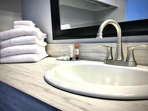 a bathroom with a sink and a mirror and towels at Empire Lakeshore Inn in Empire
