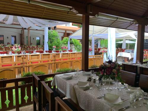 a dining room with a table with flowers on it at Hotel Bozhentsi in Chernevtsi