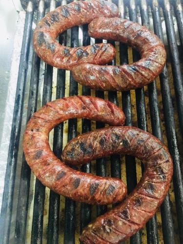 a group of sausages cooking on a grill at Hotel Bozhentsi in Chernevtsi