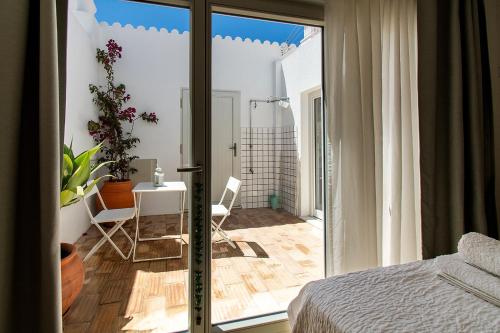 a bedroom with a sliding glass door to a patio at Casa Carolina in Vila Real de Santo António