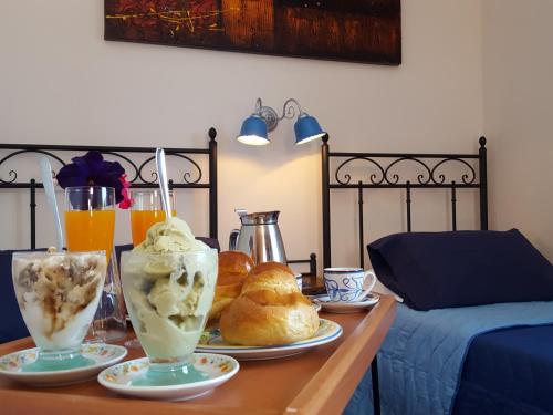a table with two glasses of ice cream and pastries at Poggiofelice B&B in Zafferana Etnea