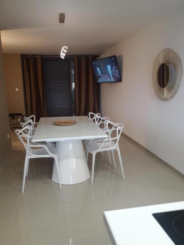 una mesa blanca y sillas en una habitación en Appartement Rêve-Catalan 2 chambres en Perpiñán