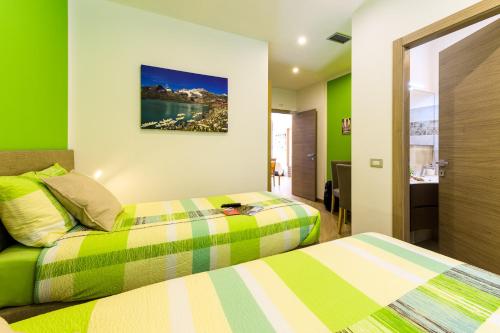 2 camas en una habitación con paredes verdes en Le Rondini, en Tirano