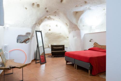 een slaapkamer met een rood bed en een stoel bij Al Sasso in Matera