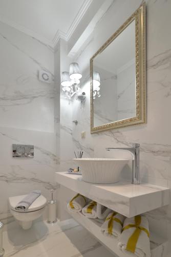 a bathroom with a sink and a toilet and a mirror at Epavlis Luxury apts in Leptokaria