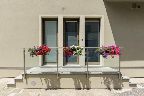 two flower pots on a balcony in front of a building at Le Rondini in Tirano