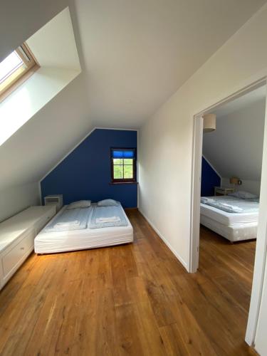 2 łóżka w pokoju z niebieskimi ścianami i drewnianą podłogą w obiekcie Dom wakacyjny Wrota Mazur w Piszu
