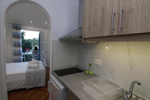 a kitchen with a sink and a bed in a room at Sea Breeze in Paleokastritsa