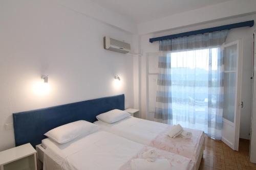 a bedroom with two beds and a window at Sea Breeze Studios in Paleokastritsa