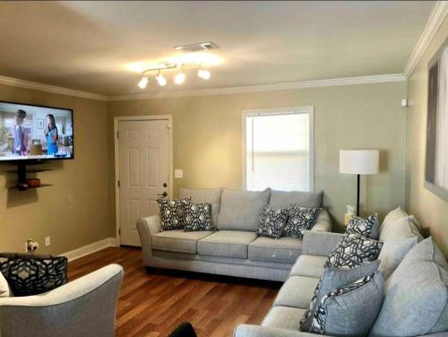 sala de estar con sofá y TV en Trinity One Apartments - Tranquility Luxury, en Jackson