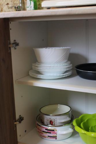 a shelf with plates and bowls in a kitchen at Apartmani Ilić in Golubac