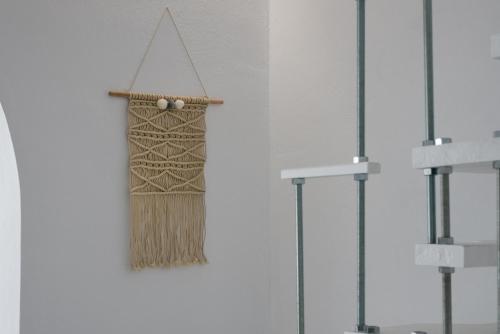 a broom hanging on a wall at Aretis home in Plaka Milou