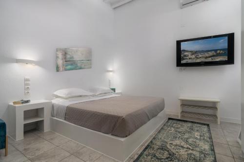 a bedroom with a bed and a tv on the wall at Aretis home in Plaka Milou