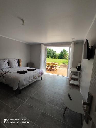 - une chambre avec un lit et une terrasse avec une table dans l'établissement Au pied du Lariat, à Léoville