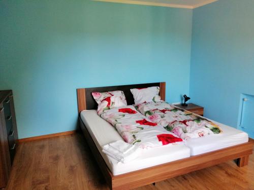 a bed in a room with a blue wall at Tanie noclegi w Bieszczadach in Hoczew