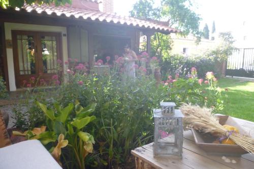 a garden with flowers and a table with a lantern at Small Guesthouse In The Garden in Amarinthos