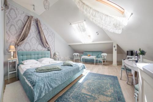 1 dormitorio con 1 cama azul, mesa y sillas en Apartamenty Kurort, en Kołobrzeg