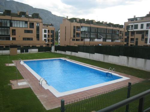 a large swimming pool in a yard with buildings at DavidSara in Llanes