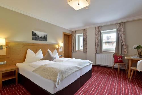 een hotelkamer met een groot bed en een bureau bij Pension Eberharter in Mayrhofen
