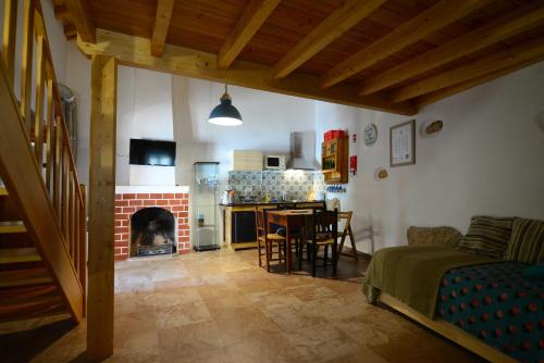 a living room with a fireplace and a kitchen at Casa do Guardado in Monsanto