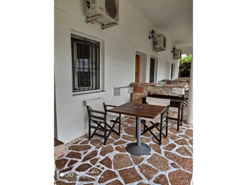 a dining room with a table and chairs on a rug at John's Guesthouse in Ksamil