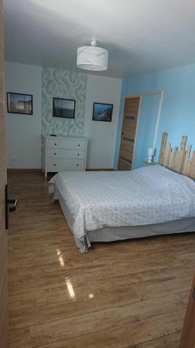 een slaapkamer met een bed en een dressoir bij L'abri côtier in Équihen-Plage
