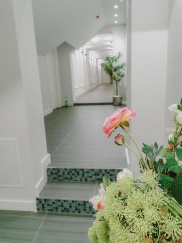 a hallway with flowers and stairs in a building at Vazdušna Banja in Niš