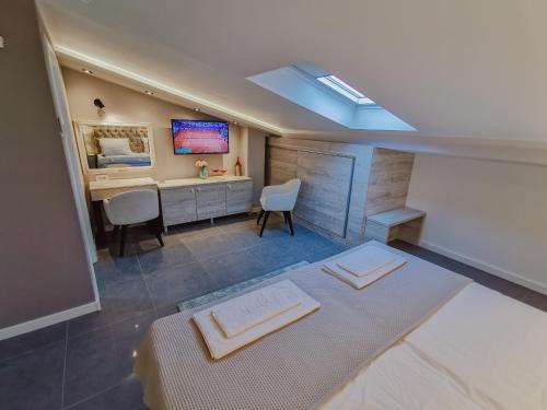 a room with a bed and a desk and a tv at Vazdušna Banja in Niš